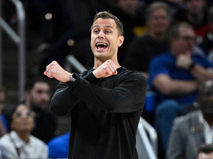 Jon Scheyer makes his arms form an X